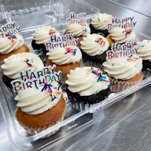 A dozen mix of chocolate and vanilla cupcakes with vanilla icing and sprinkles. Garnished with (6) Happy Birthday Toppers