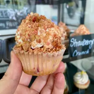 Strawberry cupcake with vanilla icing and strawberry crunch topping garnish