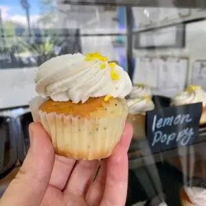 Lemon poppy flavored cupcake with vanilla icing and sprinkle garnish